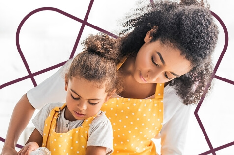 mother and daughter in yellow aprons doing something together